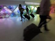 Passengers walk through an airport in Miami.