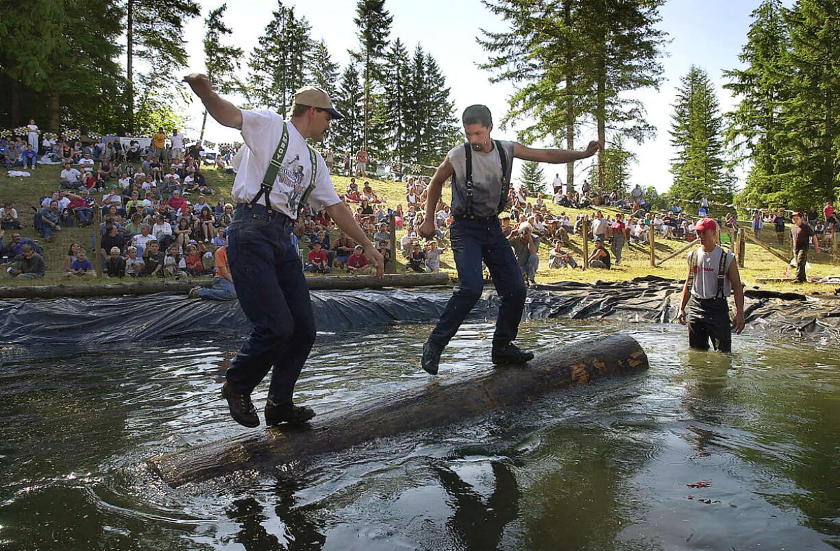 Cliff Campbell, left, and Greg Brown, both of Amboy, compete in the log roll event during a recent Territorial Days logging show.