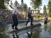 Cliff Campbell, left, and Greg Brown, both of Amboy, compete in the log roll event during a recent Territorial Days logging show.