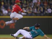 Los Angeles Angels shortstop Erick Aybar, left, completes a double play as Seattle Mariners' Kyle Seager slides into second base during the sixth inning Friday.