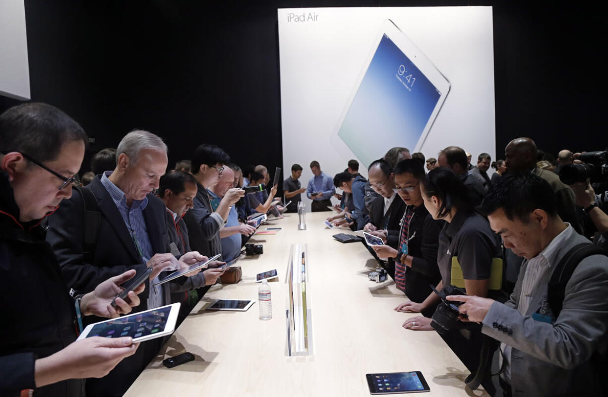 Apple employees and journalists demonstrate the new iPad Air and iPad mini on Oct.