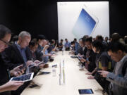 Apple employees and journalists demonstrate the new iPad Air and iPad mini on Oct.