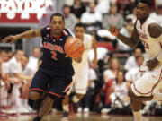 Arizona guard Mark Lyons (2) moves the ball up court after stealing a pass intended for Washington State forward D.J. Shelton, right, during the second half Saturday.