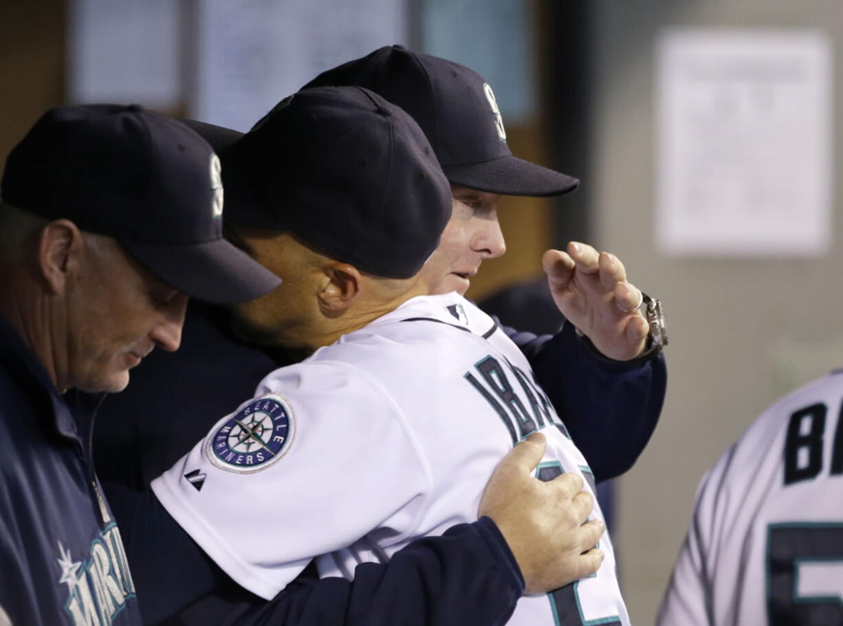 Seattle Mariners manager Eric Wedge, right, hugs Raul Ibanez after Ibanez came out of the game on Sunday.