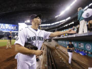 Seattle Mariners outfielder Raul Ibanez tosses a cap he autographed back to a fan after the Mariners' final game of the season Sunday at Safeco Field.