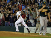 Seattle Mariners' Kendrys Morales, left, rounds the bases after he hit a walkoff three-run home run to give the Mariners a 6-3 win over the Oakland Athletics in the 10th inning Sunday.