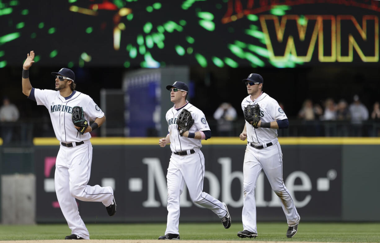 Seattle Mariners outfielders Michael Morse, left, Jason Bay and Michael Saunders head toward the infield after the team beat the Oakland Athletics 6-1 on Sunday.