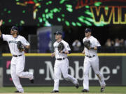 Seattle Mariners outfielders Michael Morse, left, Jason Bay and Michael Saunders head toward the infield after the team beat the Oakland Athletics 6-1 on Sunday.