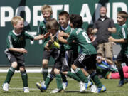 Don Ryan/The Associated Press
Atticus Lane-Dupre, 8, third from left, is congratulated by his teammates on the Green Machine soccer team after scoring the winning goal against the Portland Timbers. More than 3,000 fans came to Jeld-Wen Field to attend the Make-A-Wish matchup for a young cancer survivor.