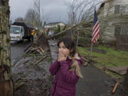 Battle Ground resident Bela Morgan, 9, reacts to seeing damage and debris along Southeast Rasmussen Boulevard from a tornado while viewing the aftermath with her family Thursday afternoon, Dec. 10, 2015.