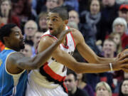 Portland Trail Blazers forward Nicolas Batum, right, from France, looks for help as New Orleans Hornet guard Roger Mason Jr., defends during the first quarter of an NBA basketball game in Portland on  Dec.