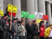 Beer brewers and others gather Friday in front of the state Capitol in Olympia to protest a proposal that would permanently extend a temporary beer tax on large brewers and would extend it to include small brewers.