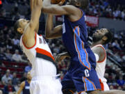 Charlotte's Bismack Biyombo (0) shoots against Portland's Nicolas Batum, left, and JJ Hickson during the first half Monday.