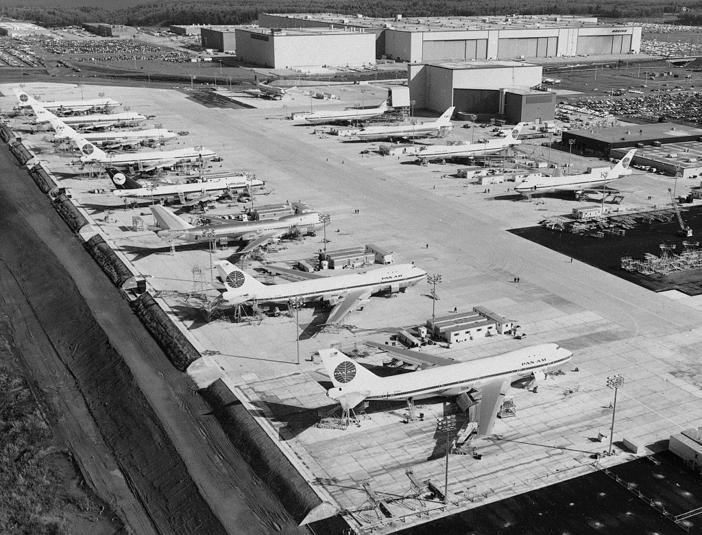 Workers are dwarfed by the immensity of Boeing 747 jumbo jet nearing completion at the company's plant at Everett.