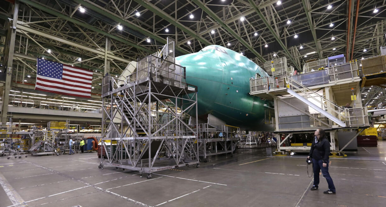 A visitor looks up at a Boeing 747 jet being assembled at the company's production plant in Everett in May.