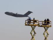 Boeing Co. workers stand on platforms as they wave at the last C-17 Globemaster III cargo jet built for the U.S.