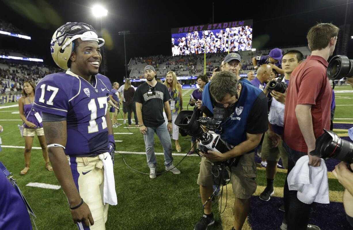 Washington quarterback Keith Price (17) enjoys the spotlight as he waits for a TV interview after Washington beat Boise State 38-6, on Aug. 31.