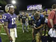 Washington quarterback Keith Price (17) enjoys the spotlight as he waits for a TV interview after Washington beat Boise State 38-6, on Aug. 31.