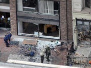 One of the blast sites on Boylston Street near the finish line of the 2013 Boston Marathon is investigated by two people in protective suits in the wake of two blasts in Boston on Monday.