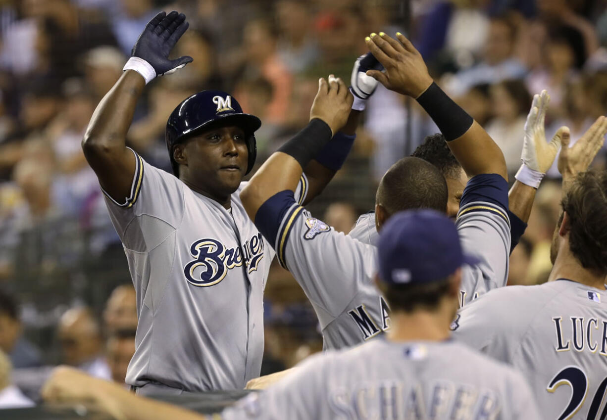 Milwaukee Brewers' Yuniesky Betancourt, left, a former Seattle Mariner, is greeted at the plate after he hit a grand slam against his former club in the fifth inning Friday at Safeco Field.