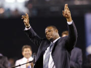 Former Seattle Mariners outfielder Ken Griffey Jr., center, waves to fans as he steps up to speak during a pregame ceremony to induct him into the team's Hall of Fame, Saturday, Aug. 10, 2013, in Seattle. Applauding behind him are former teammates Jay Buhner, left, Edgar Martinez and Dan Wilson.