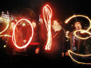 Katy Saunders, left, Alex Mueller, center left, Rebekka Frank and Arina Motamedi, right, play with sparklers ahead of welcoming in the new year during the 2013 Edinburgh Hogmanay celebrations, Scotland, Monday December 31, 2012. See PA story SOCIAL NewYear.