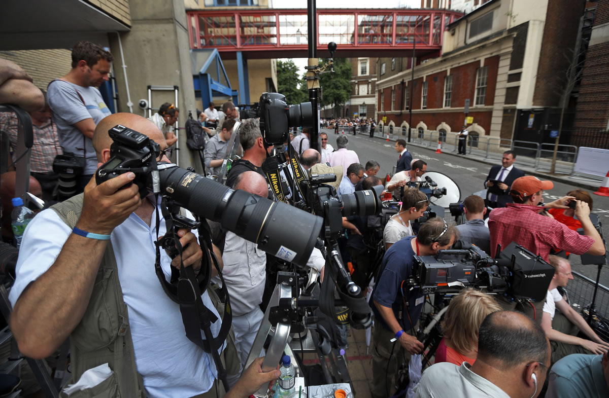 Members of the media wait across St.