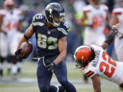 Seattle Seahawks' Doug Baldwin runs with the ball after a pass reception as Cleveland Browns' Tramon Williams falls behind in the second half of an NFL football game, Sunday, Dec. 20, 2015, in Seattle.