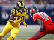 St. Louis Rams running back Todd Gurley, left, carries the ball as Tampa Bay Buccaneers outside linebacker Lavonte David defends during the second quarter of an NFL football game Thursday, Dec. 17, 2015, in St. Louis.