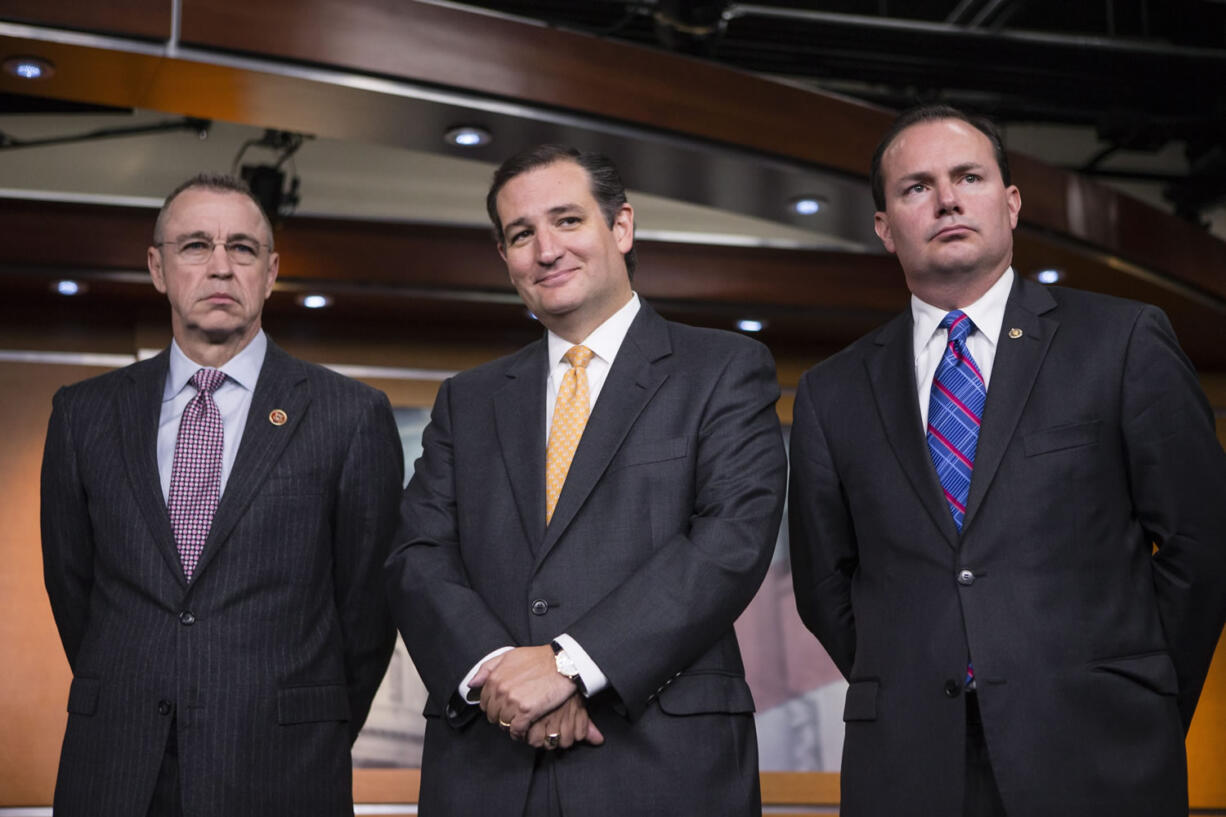 Sen. Ted Cruz, R-Texas, center, smiles during a news conference with conservative Congressional Republicans who persuaded the House leadership to include defunding the Affordable Care Act as part of legislation to prevent a government shutdown, at the Capitol in Washington on Sept. 19. Sen. Cruz is flanked by Rep. Matt Salmon, R-Ariz., left, and Sen.