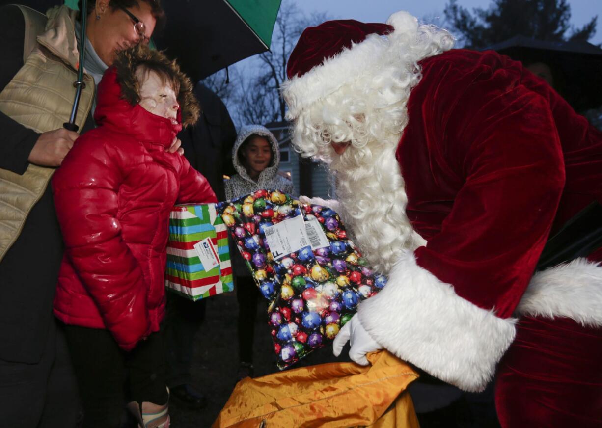 Safyre Terry, 8, receives packages from Santa Claus in Rotterdam, N.Y., on Dec. 17. Terry Lost her father and siblings in an arson fire that left her severely scarred.