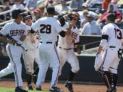 Oregon State's Max Gordon (4) and Andy Peterson (14) celebrate with teammates Ben Wetzler (28) and Jake Rodriguez (13) after they scored on a two-run single by Dylan Davis against Louisville in the fourth inning Monday.