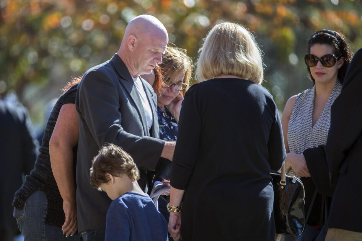 David O'Steen, center, talks with friends after the service for his high school friend Shannon Johnson at the Calvary Baptist Church in Jesup, Ga., Saturday, Dec. 12, 2015. Shannon Johnson died in the mass shooting in San Bernardino, Calif., on Dec. 2. (AP Photo/Stephen B.