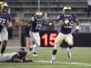 Washington's Bishop Sankey (25) takes off on a 59-yard touchdown run as quarterback Keith Price (17) cheers behind in the first half of an NCAA college football game against California Saturday, Oct. 26, 2013, in Seattle.