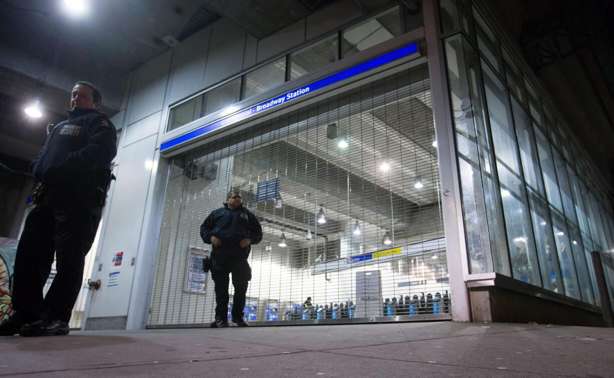 Transit security officers stand outside the Commercial-Broadway Skytrain station after the commuter train system was shut down to check for any possible damage to elevated guideways in Vancouver, B.C., early Wednesday after an earthquake struck off the western coast late Tuesday night. The moderate quake struck at 11:39 p.m. local time Tuesday about 20 kilometres north of Victoria and was felt across much of southern British Columbia.