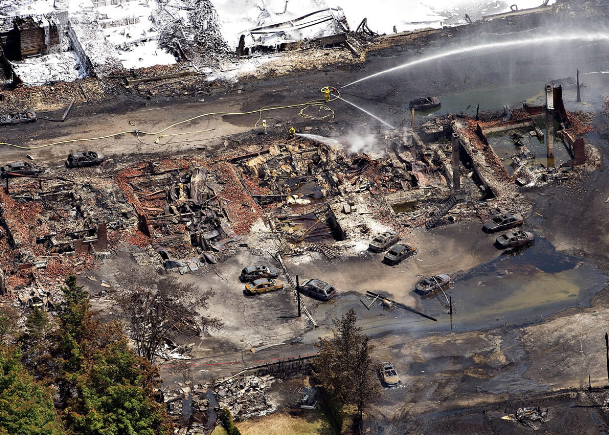 The downtown core of Lac Megantic, Quebec, lies in ruins as fire fighters continue to water smoldering rubble Sunday, July 7,  after a train derailed and tanker cars carrying crude oil exploded. Saturday's disaster at Lac Megantic is likely to influence the ongoing political debate over shipping petroleum products by rail or by pipeline.