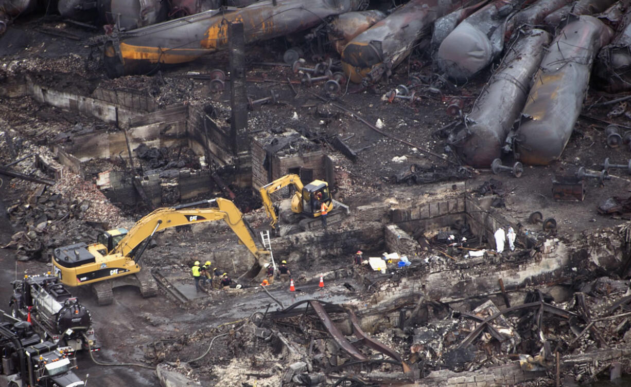 Workers comb through the debris Tuesday in Lac-Megantic, Quebec.