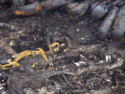 Workers comb through the debris Tuesday in Lac-Megantic, Quebec.