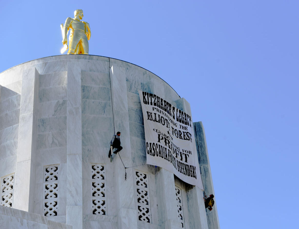 Protesters with the Cascadia Forest Defenders hang a protest banner on  the Oregon State Capitol Dome  in Salem, Ore., on Thursday.