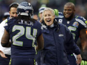 Seattle Seahawks head coach Pete Carroll congratulates running back Marshawn Lynch (24) after Lynch scored on a 20-yard touchdown run during the first quarter of an NFL football game against the Arizona Cardinals in Seattle, Sunday, Dec. 9, 2012.