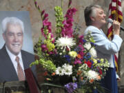 Rep. Maureen Walsh sings during a memorial service on the Senate floor for the late Sen. Mike Carrell, pictured left, on Monday in Olympia .