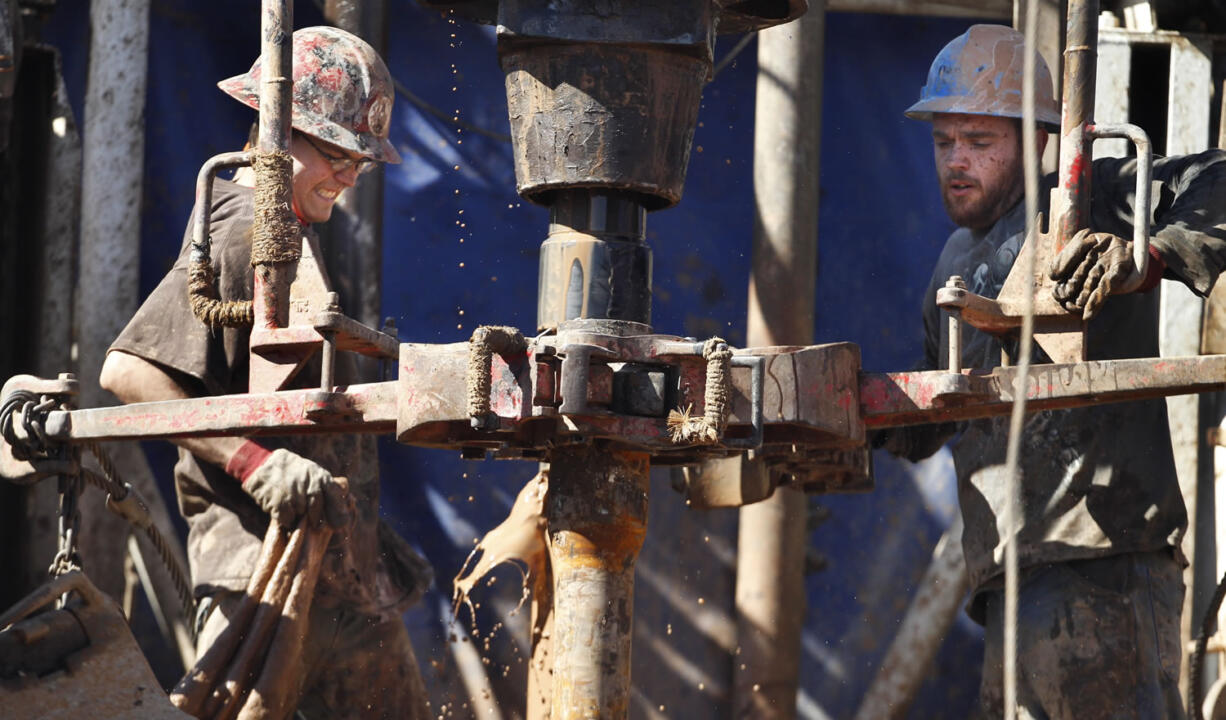 Oil field workers drill into the Gypsum Hills near Medicine Lodge, Kan. With OPEC unwilling to cut back on production, low oil prices seem almost guaranteed for at least the next few months.