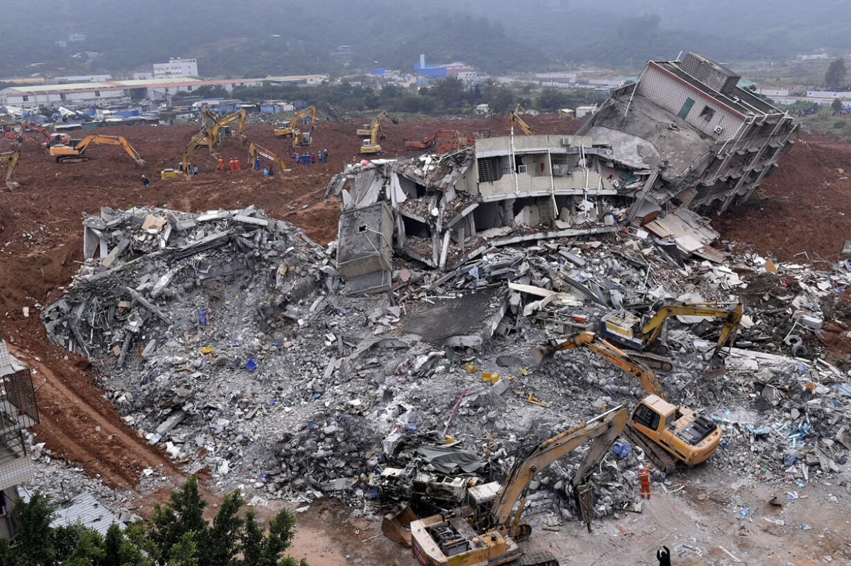 Rescuers on foot and in excavating machines seek survivors Monday in the rubble of buildings and under the red mud of Sunday&#039;s landslide in Shenzhen, China, in which a mountain of excavated soil and construction waste that had been piled up over two years collapsed.