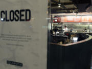 People stand inside a closed Chipotle restaurant on Monday in the Cleveland Circle neighborhood of Boston. Chipotle said late Monday that it closed the restaurant after several students at Boston College, including members of the men&#039;s basketball team, reported &quot;gastrointestinal symptoms&quot; after eating at the chain. The school said it was working with local health officials to determine the cause of the illness.