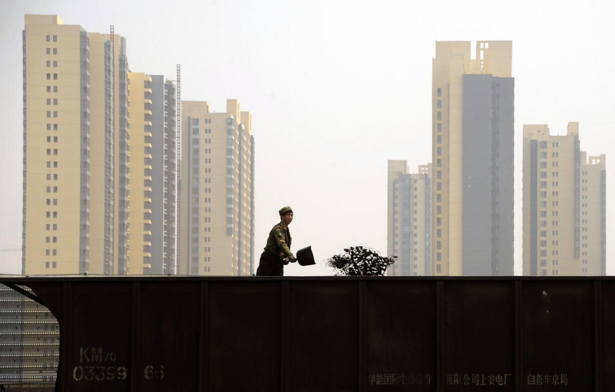 A worker shovels coal on a freight train in Taiyuan in northern China's Shanxi province.