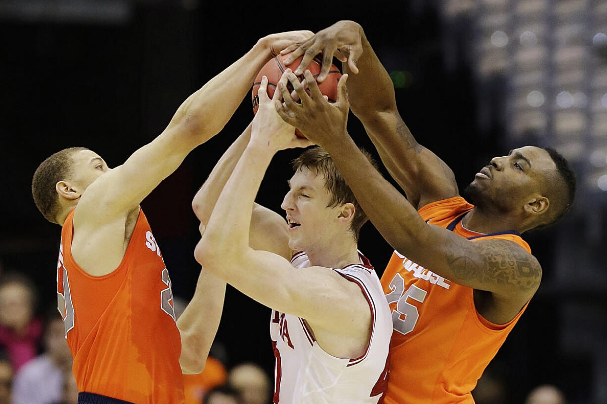 Indiana forward Cody Zeller (40) is trapped between Syracuse guard Brandon Trich, left, and forward Rakeem Christmas (25) during the first half of an East Regional semifinal in the NCAA college basketball tournament, Thursday, March 28, 2013, in Washington.