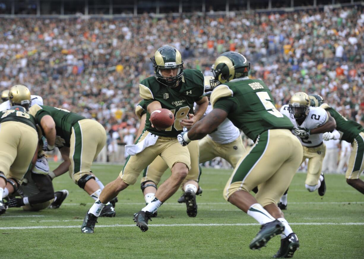 Colorado State Rams quarterback Garrett Grayson (18) hands off to running back Kapri Bibbs (5) against Colorado during the second half Sunday in Denver.