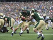 Colorado State Rams quarterback Garrett Grayson (18) hands off to running back Kapri Bibbs (5) against Colorado during the second half Sunday in Denver.