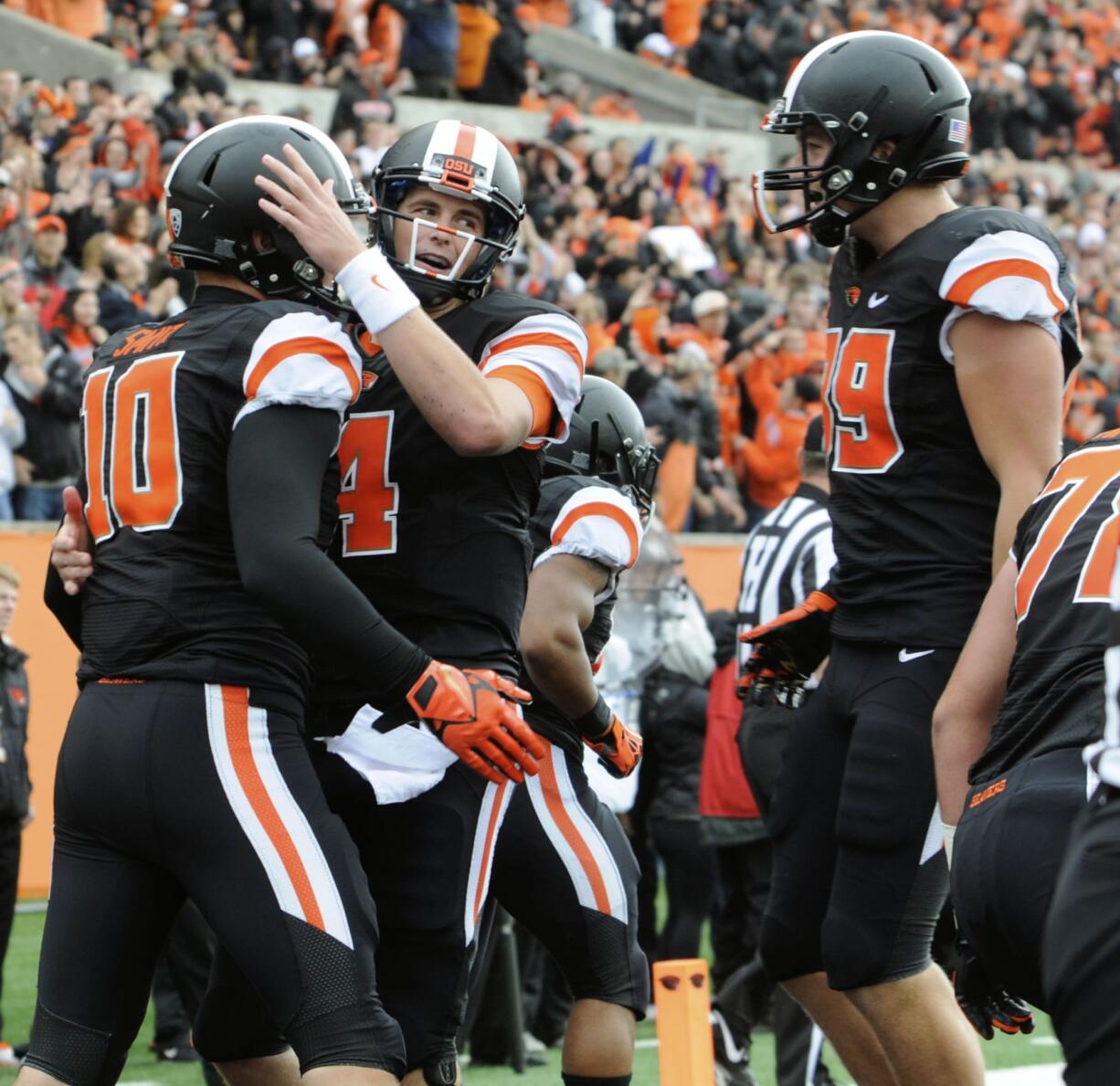 Oregon State's quarterback Sean Mannion (4) congratulates Caleb Smith (10) on his touchdown reception against Colorado in the first half Saturday.