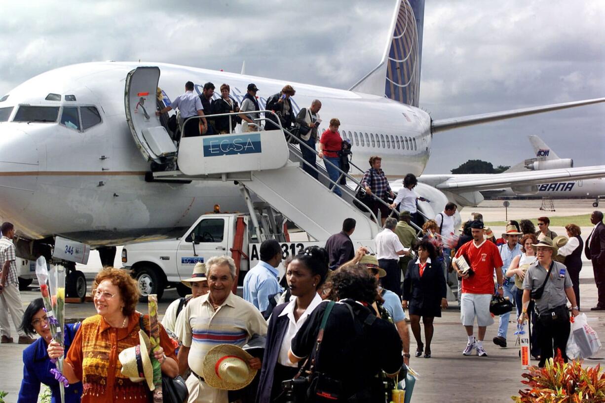 Passengers aboard the first flight of Continental Airlines from Miami, Fla., to Cuba arrive at Jose Marti Airport in Havana on Nov. 1, 2001.